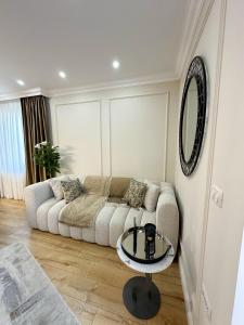 a living room with a couch and a glass table at Porcelain Apartment in Rădăuţi