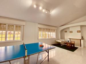 a blue ping pong table in a room with a table at Alameda House in Santa Marta de Ortigueira