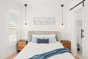 a white bedroom with a bed with blue pillows at Cozy Retreat Near Downtown - Perfect for Families in Long Beach