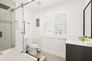 a bathroom with a shower and a toilet and a sink at Cozy Retreat Near Downtown - Perfect for Families in Long Beach +54 photos