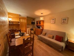 a living room with a couch and a table at Mottaret - 2 pièces - Pied des pistes avec vue - Parking in Les Allues