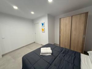 a bedroom with a bed with a white towel on it at Edificio Mañez - Bajo in La Línea de la Concepción