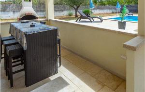 a outdoor kitchen with a grill and a swimming pool at Awesome Home In Mihelici With Wifi in Buici