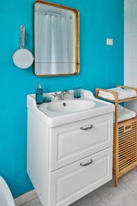 a bathroom with a white sink and a mirror at La Casita de la Playa Escondida in Tal