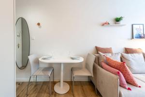 アヌシーにあるLac Pershing - Appartement confortable à deux pas du lacのテーブル、ソファ、枕が備わる客室です。