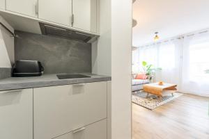 アヌシーにあるLac Pershing - Appartement confortable à deux pas du lacの白いキャビネットとテーブル付きのキッチン