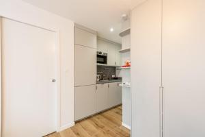 アヌシーにあるLac Pershing - Appartement confortable à deux pas du lacの白いキャビネット付きのキッチン、スライドドア +16枚の写真