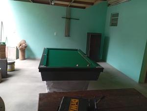 a green pool table in a room with a cross at MICRO CASA DE SITIO DO TIO Tonho in Blumenau