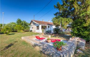 dom z czerwonymi krzesłami na kamiennej ścianie w obiekcie 2 Bedroom Awesome Home In Vodnjan w mieście Vodnjan