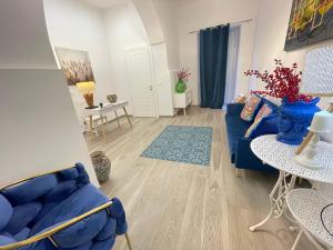 a living room with a blue couch and a table at Domus Federiciana in Castellammare del Golfo