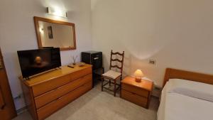 San BartolomeoにあるVilla Angelicaのベッドルーム(ベッド1台、テレビ、鏡付)