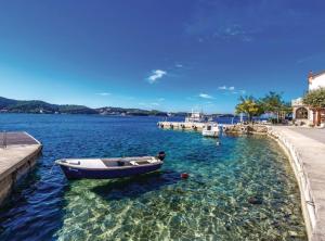 a boat in the water next to a dock at Holiday Home Boni in Rab