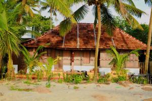 a building with palm trees in front of it at Beachillam in Alleppey