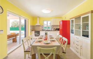 a kitchen with a table with chairs and a red refrigerator at Beautiful Home In Vodnjan With Kitchen in Vodnjan