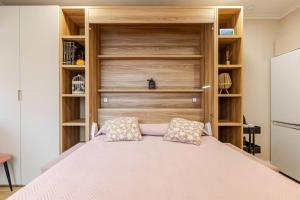 Schlafzimmer mit einem großen Bett und Holzregalen in der Unterkunft New! Cozy for couples with private patio in Sevilla