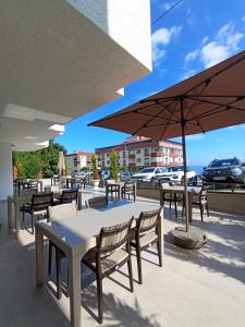 a patio with tables and chairs and an umbrella at Erom Otel in Trabzon