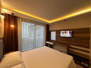 a bedroom with a bed and a flat screen tv at Erom Otel in Trabzon