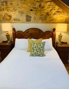 a bedroom with a white bed with two lamps at Clare Valley Heritage Retreat in Clare
