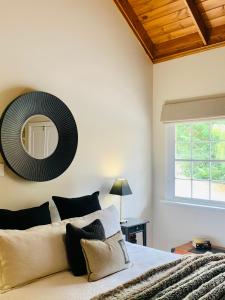 a bedroom with a bed with a mirror on the wall at Clare Valley Heritage Retreat in Clare