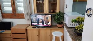 una TV su un supporto in legno in una stanza di Bungalow Manuel 217 en Gran Alacant a Gran Alacant Altre 61 foto