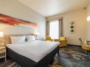 Postel nebo postele na pokoji v ubytování Ibis Styles Dragon Mart Dubai