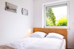 two beds in a room with a window at DKK1c Ferienwohnung Mole 1 in Niendorf