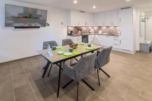 a kitchen and dining room with a table and chairs at Oase am Siel 4 in Dornumersiel
