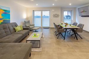 a living room with a couch and a table at Oase am Siel 4 in Dornumersiel +16 photos