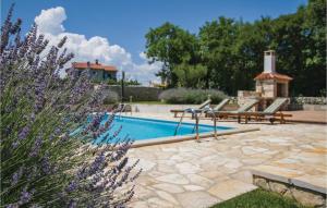 a swimming pool with two chairs and a gazebo at Holiday Home Kunj Croatia in Kunj