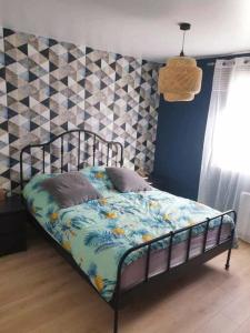 a bedroom with a bed with a patterned wall at Charmante maison proche plage et port in Camaret-sur-Mer +7 photos