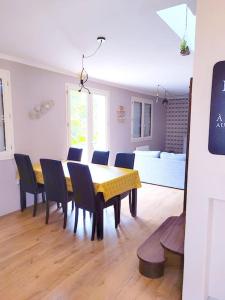 a dining room with a table and chairs and a couch at Charmante maison proche plage et port in Camaret-sur-Mer