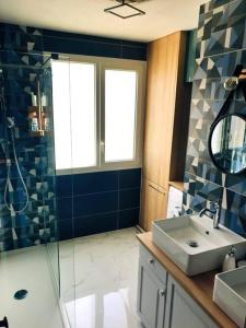 a bathroom with a sink and a shower and a mirror at Charmante maison proche plage et port in Camaret-sur-Mer