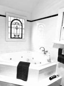 a white bathroom with a bath tub and a window at Clare Valley Heritage Retreat in Clare +11 photos