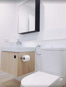 a bathroom with a toilet and a sink and a mirror at Modern 5-Guest Pool Retreat for Family & Business in Brisbane