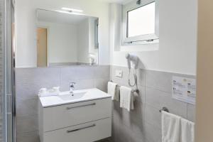 a bathroom with a sink and a mirror at Hôtel Alexandra in Roquebrune-Cap-Martin