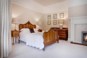 una camera con un grande letto e un camino di Richmond Place - Apartment in Private Mansion a Kendal