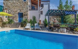 a swimming pool with two chairs and a house at Holiday Home Kamena Vas Kamena Vas in Karojba
