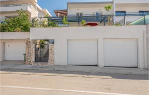 two white garage doors on a white building at Holiday Home Makarska 26 in Makarska +16 photos