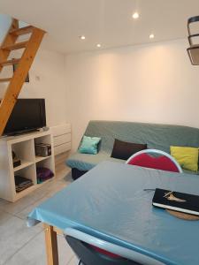 a living room with a couch and a table at Studio privé à la campagne in Guillerval