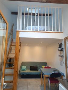 a room with a couch under a loft bed at Studio privé à la campagne in Guillerval