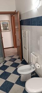 a bathroom with a toilet and a checkered floor at B&B Home Sweet Home in Diano Marina