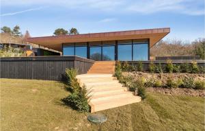 a house with a wooden staircase in front of it at Awesome Home In Knebel With Sauna in Knebel