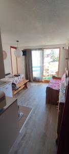 una sala de estar con un sofá y una mesa en F2 front de neige la Rosière, en La Rosière