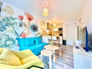 a living room with a blue couch and a table at L’entrelacs in Équemauville