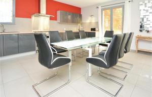 a dining room with a glass table and black chairs at Awesome Home In Saint-Rémy-De-Provence in Saint-Rémy-de-Provence