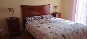 a bedroom with a bed with a swan on it at La belleza del Tietar in Lanzahita