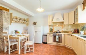 a kitchen with a table and a white refrigerator at Holiday Home Muntic Iii in Muntić +46 photos