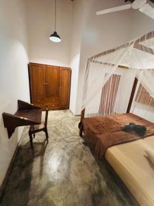 a bedroom with a canopy bed and a piano at Coastal Cloud Backpackers in Unawatuna