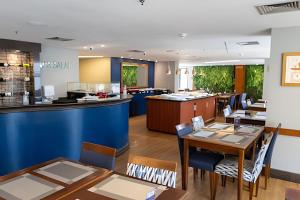 a restaurant with tables and chairs and a counter at Flat c/ Ar condicionado 550m Hospital São Paulo (UH903) in São Paulo