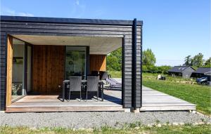 ein kleines schwarzes Haus mit einem Tisch und Stühlen in der Unterkunft Lovely Home In Allinge With Wifi in Allinge